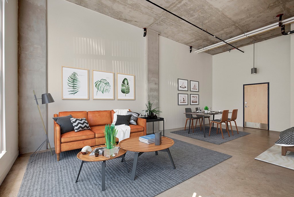 A living room with a couch, coffee table, and pictures on the wall at RiDE at RiNo Apartments, Denver, Colorado