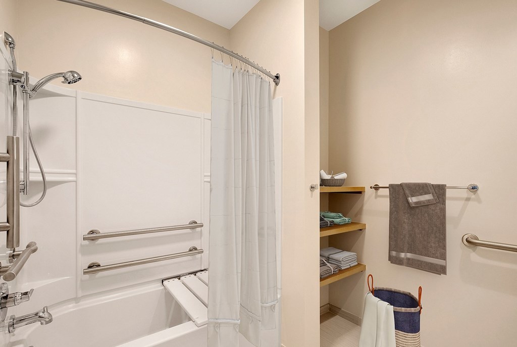 A white bathroom with a shower and a towel rack at RiDE at RiNo Apartments, Denver
