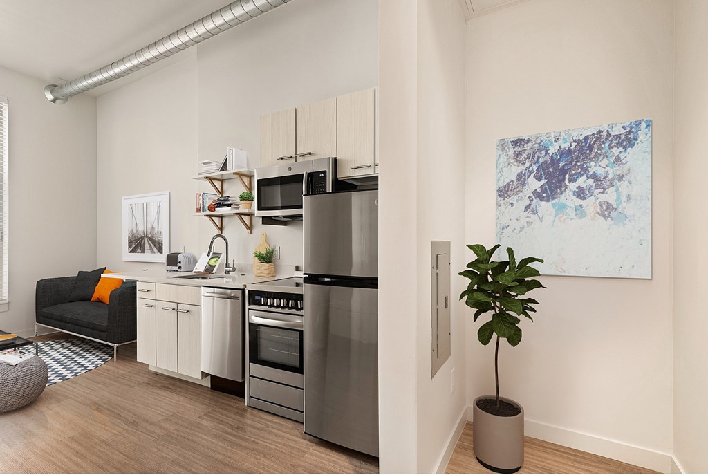 A modern kitchen with a refrigerator, oven, and sink at RiDE at RiNo Apartments, Denver, CO