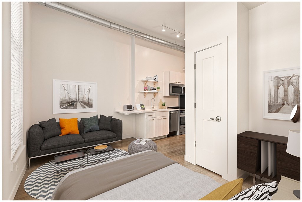 A living room with a grey couch and a grey rug. at RiDE at RiNo Apartments, Denver