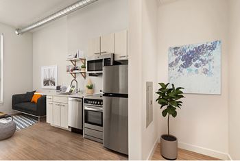 A modern kitchen with a refrigerator, oven, and sink. at RiDE at RiNo Apartments, Colorado
