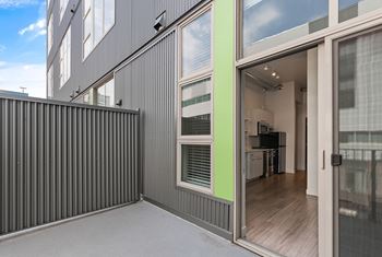 A modern house with a grey exterior and a glass door leading to the interior. at RiDE at RiNo Apartments, Denver, CO