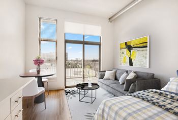 A well-lit bedroom with a large bed and a painting on the wall. at RiDE at RiNo Apartments, Colorado