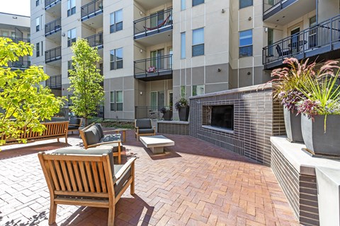A patio with a bench and a fireplace in front of a building at Regatta Sloans Lake Apartments, Denver, 80204