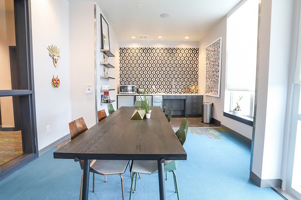 A dining room with a wooden table and chairs at RiDE at RiNo Apartments, Denver, CO