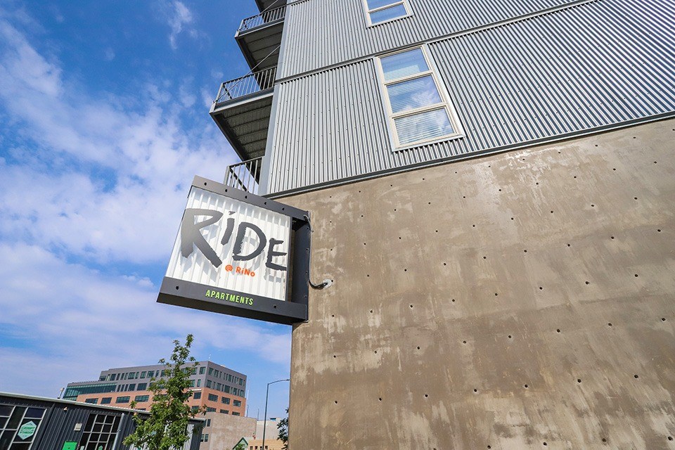A building with a sign at RiDE at RiNo Apartments, Denver, CO, 80216