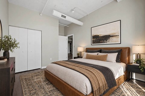 A bedroom with a large bed and a painting on the wall.