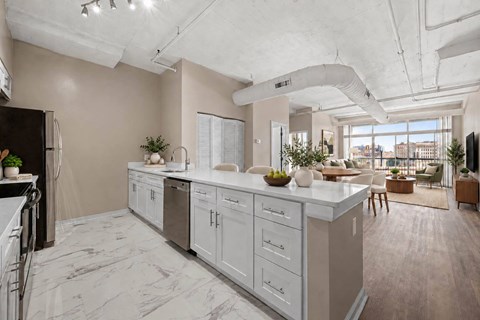 A modern kitchen with a marble countertop and stainless steel appliances.