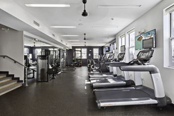 a gym with treadmills and other cardio equipment in a building at West 130, West Hempstead, New York