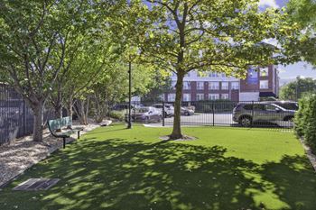 a park with green grass and trees and a fence at West 130, New York , 11552