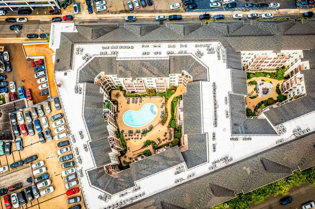 an aerial view of a building with a pool and parking lot at Metro 303, Hempstead, NY