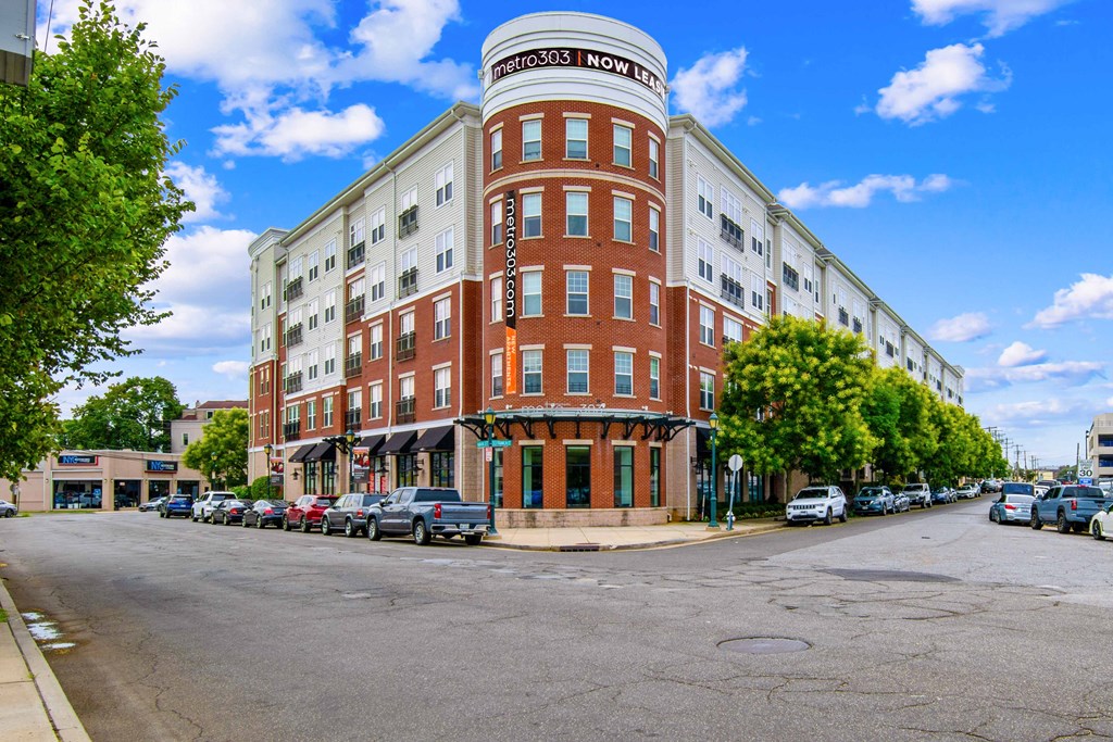 a building on the corner of a street with cars parked in front of it at Metro 303, Hempstead, NY 11550