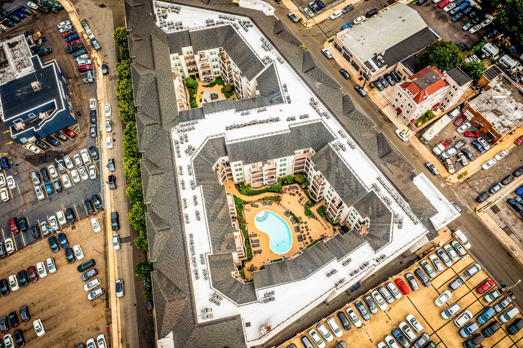 an aerial view of an apartment complex with a swimming pool and parking lot at Metro 303, Hempstead New York