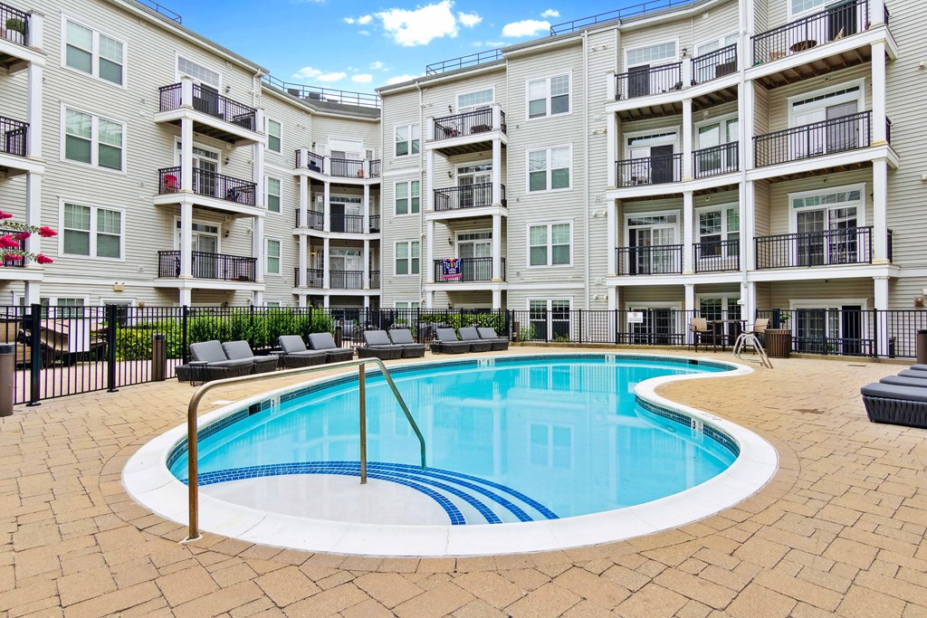 a swimming pool in front of an apartment building at Metro 303, Hempstead