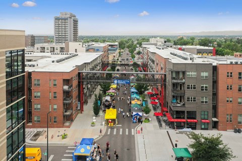 A busy street scene with people walking and cars driving at Regatta Sloans Lake Apartments, Denver, CO