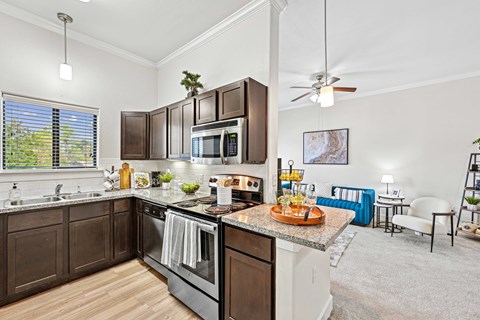 A modern kitchen with dark brown cabinets and a large island.