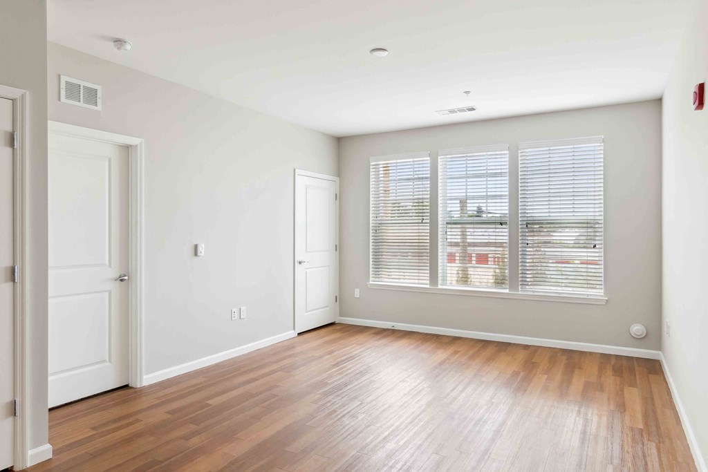 a bedroom with hardwood floors and a large window at West 130, New York , 11552