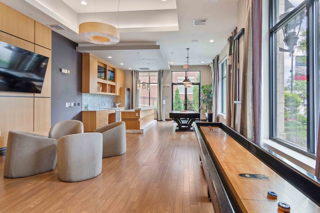 a foosball table sits in the middle of a room with a pool table and chairs at West 130, New York