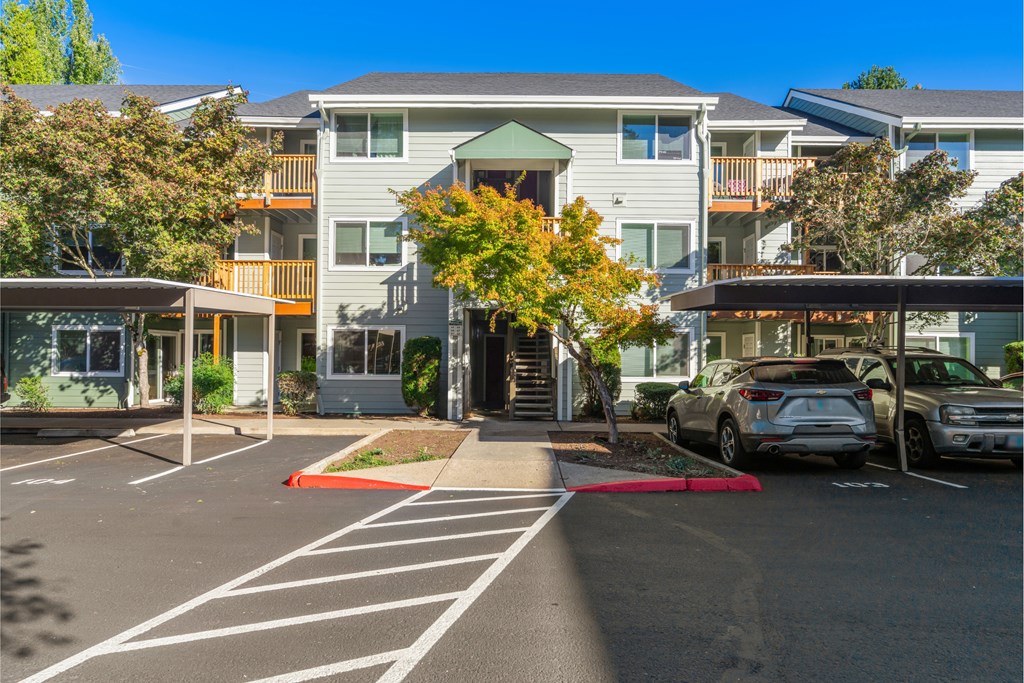 A parking lot with cars and apartment buildings in the background.