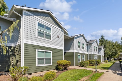 A row of houses with green and grey siding.