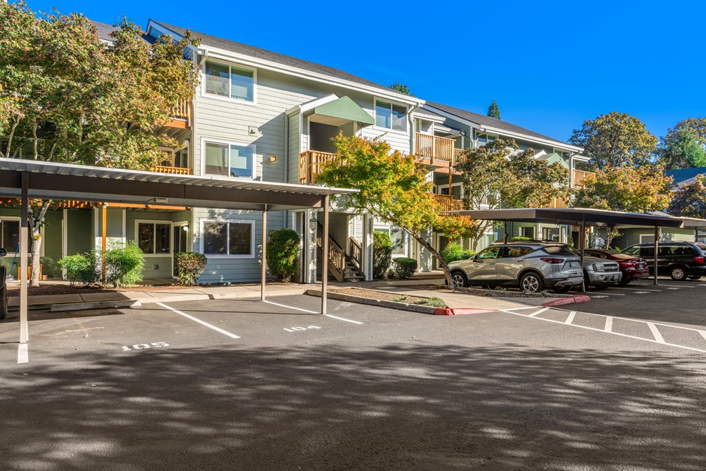 A parking lot with cars and apartment buildings in the background.