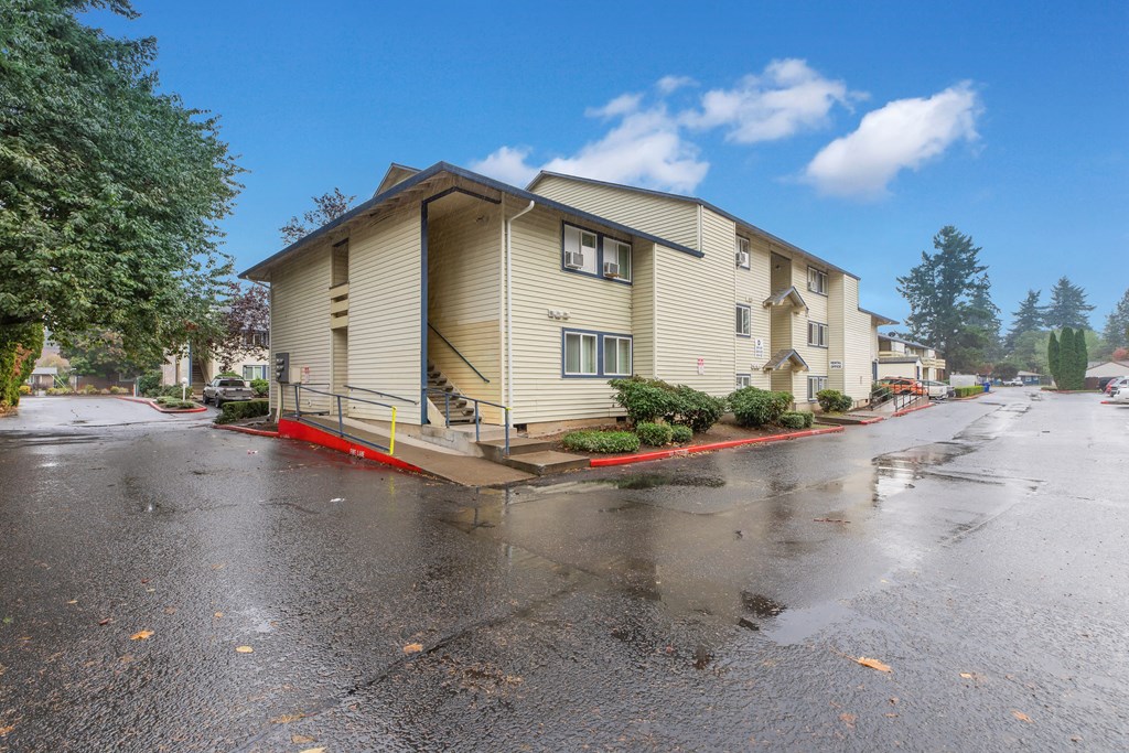 the view of an apartment building from the street in the rain