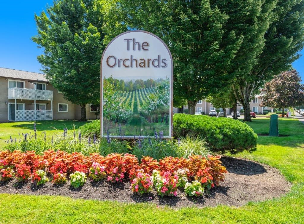 a picture of the orchards sign with flowers in front of it