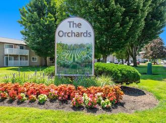 a picture of the orchards sign with flowers in front of it