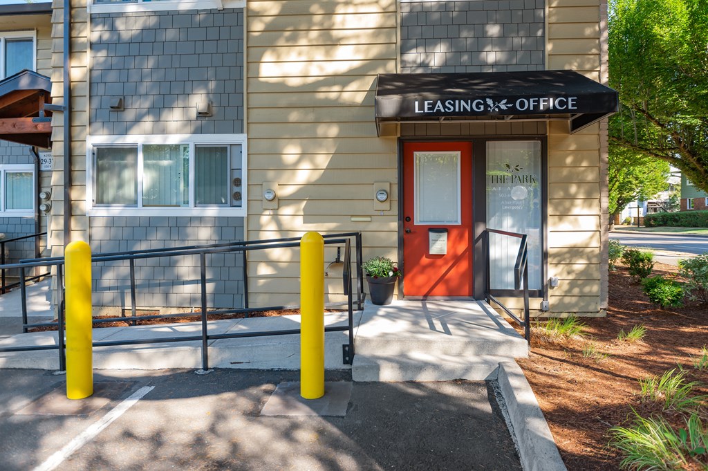 a building with a red door and a sign that reads leasing office