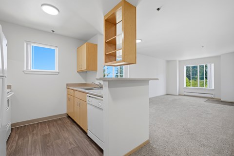 A kitchen with white appliances and wooden cabinets.