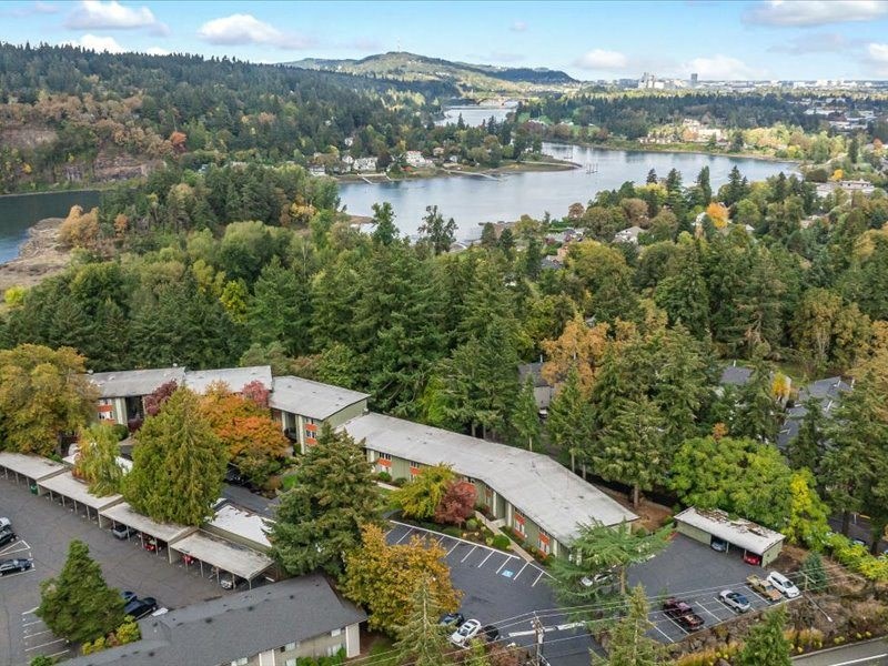 an aerial view of a building with a lake in the background
