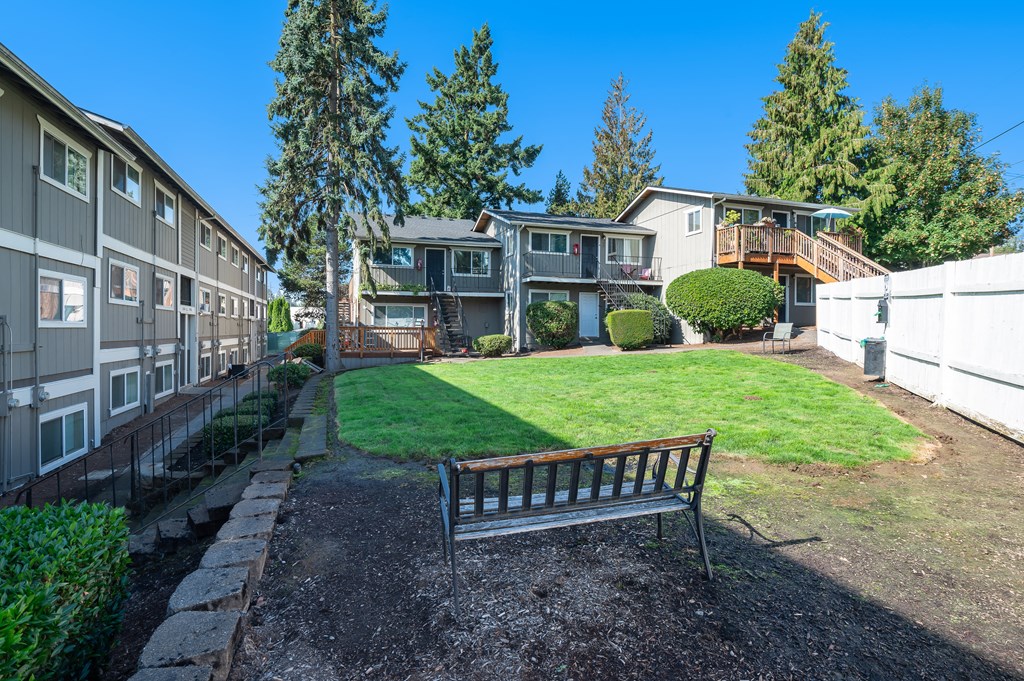 a park bench in a yard in front of houses