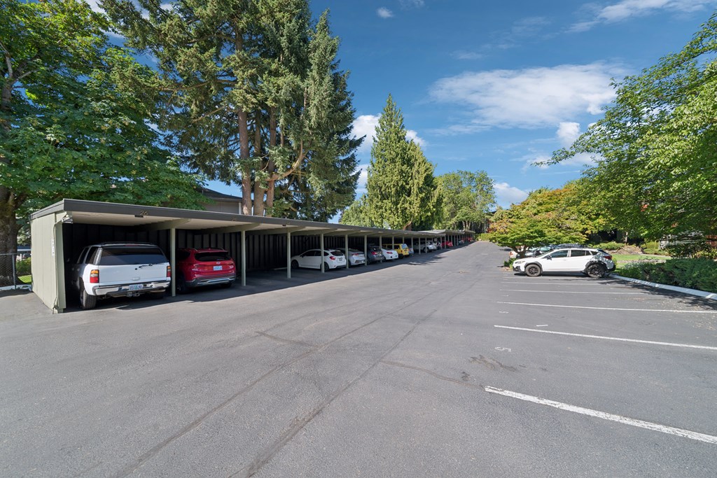 A parking lot with cars parked under a covered area.