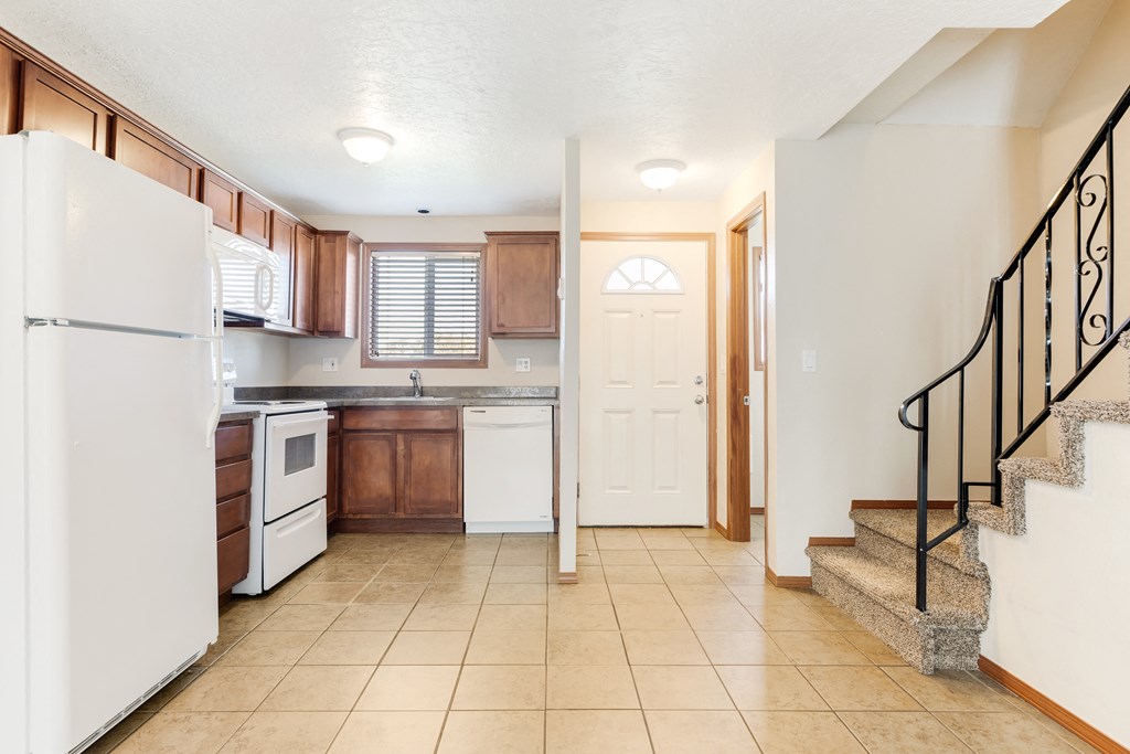 a kitchen with a white refrigerator freezer next to a stove top oven
