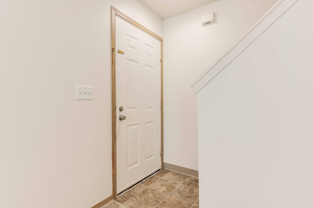 a bedroom with a white door and white walls