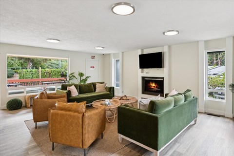 A living room with a green couch and a fireplace.