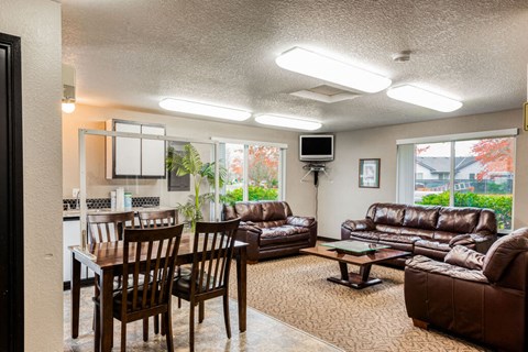 A living room with brown leather furniture and a flat screen TV mounted on the wall.