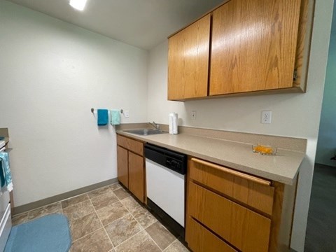 A kitchen with wooden cabinets and a tiled floor.