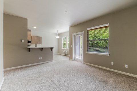 A spacious room with a window and a door leading to a balcony.
