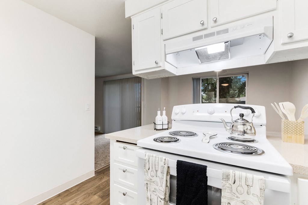 a kitchen with white appliances and white cabinets and a white stove top oven