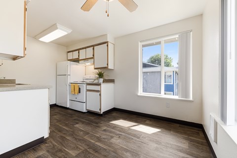 A kitchen with white cabinets and a window overlooking a building.