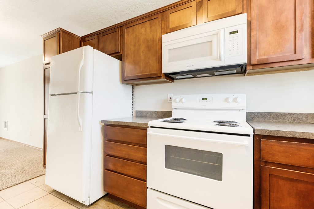 a kitchen with wooden cabinets and white appliances