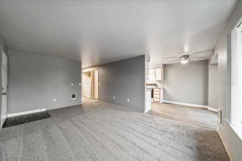 A spacious room with a carpeted floor and a doorway leading to another room.