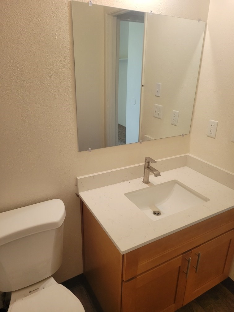 a bathroom with a sink toilet and a mirror