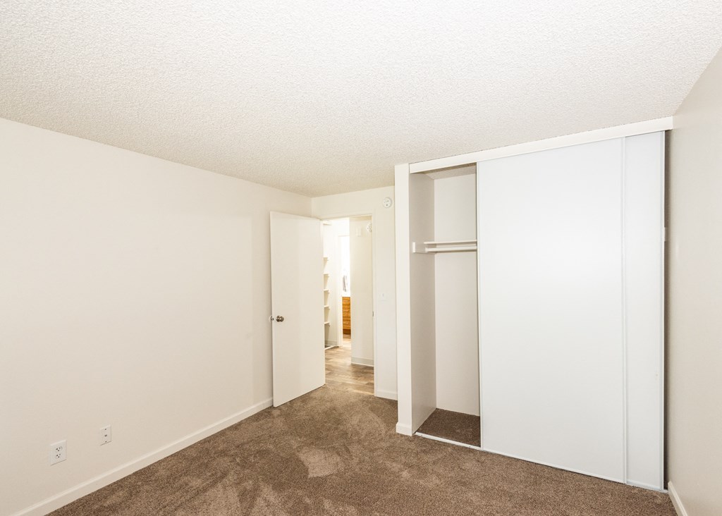 an empty bedroom with white walls and a closet