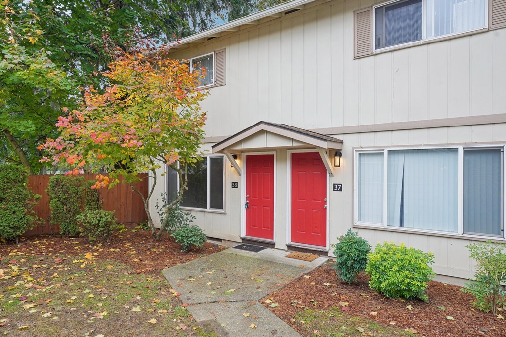 A house with a red door and a small garden in front.