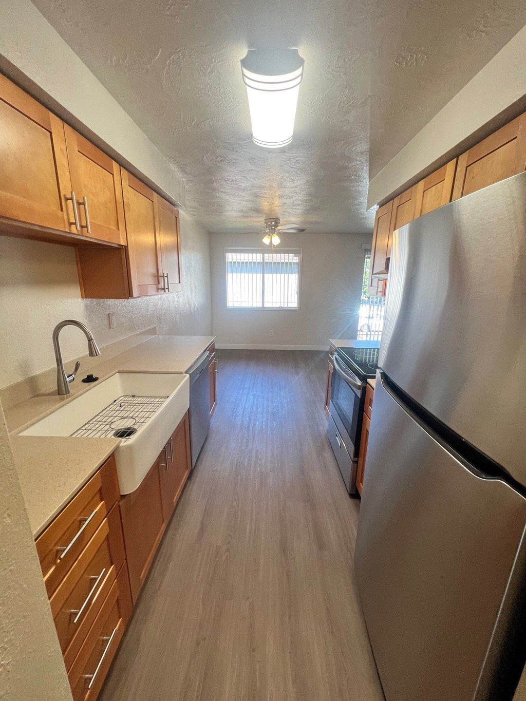 A kitchen with wooden cabinets and a stainless steel refrigerator.
