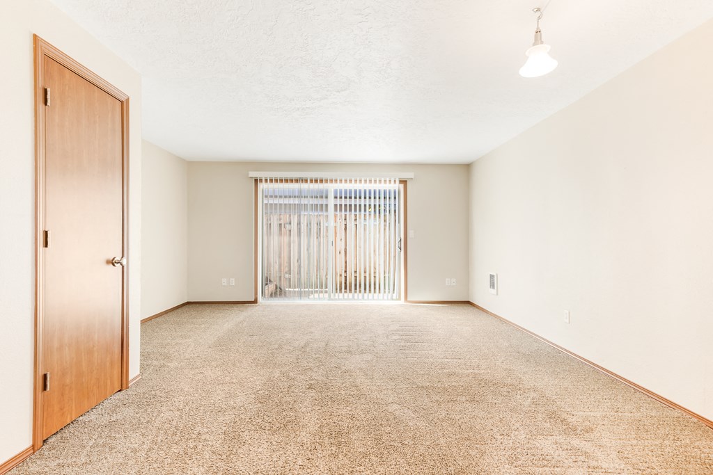 a bedroom with a door and a carpeted floor