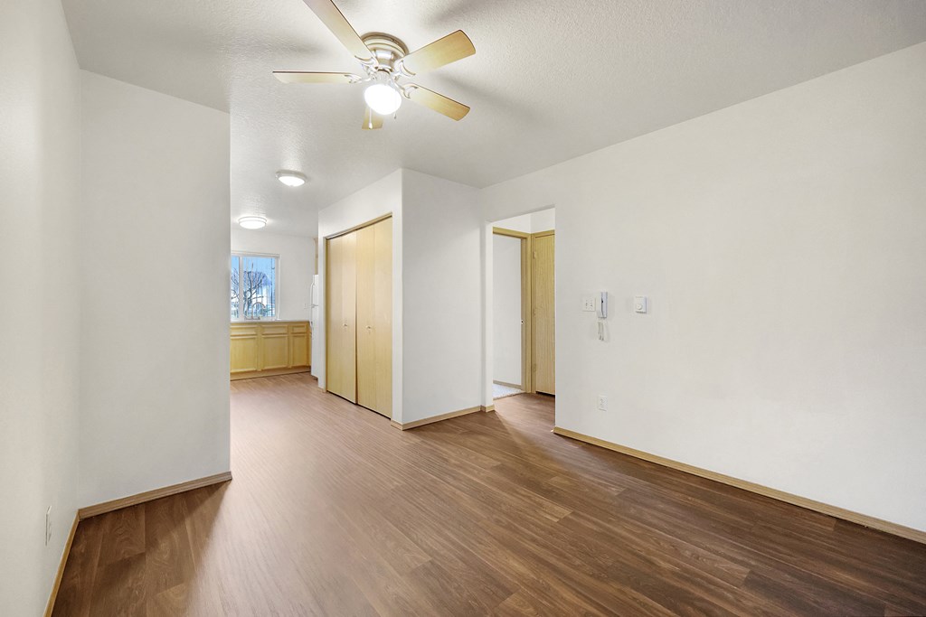 a living room with hardwood flooring and a ceiling fan