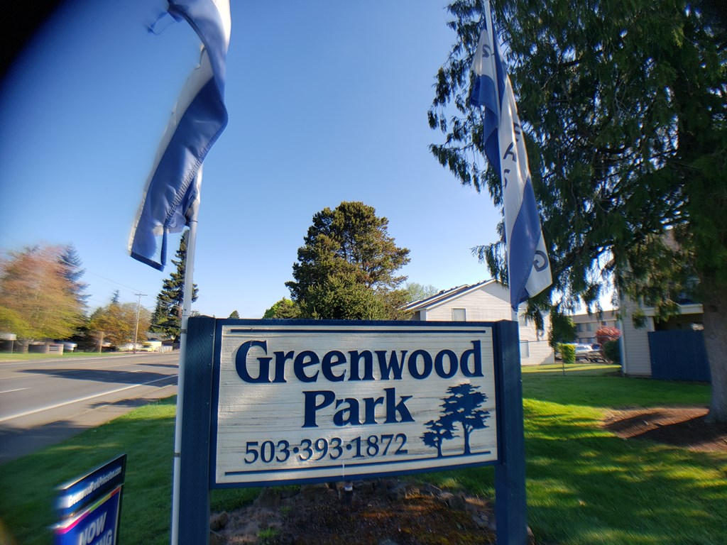 A sign for Greenwood Park with a phone number on it.